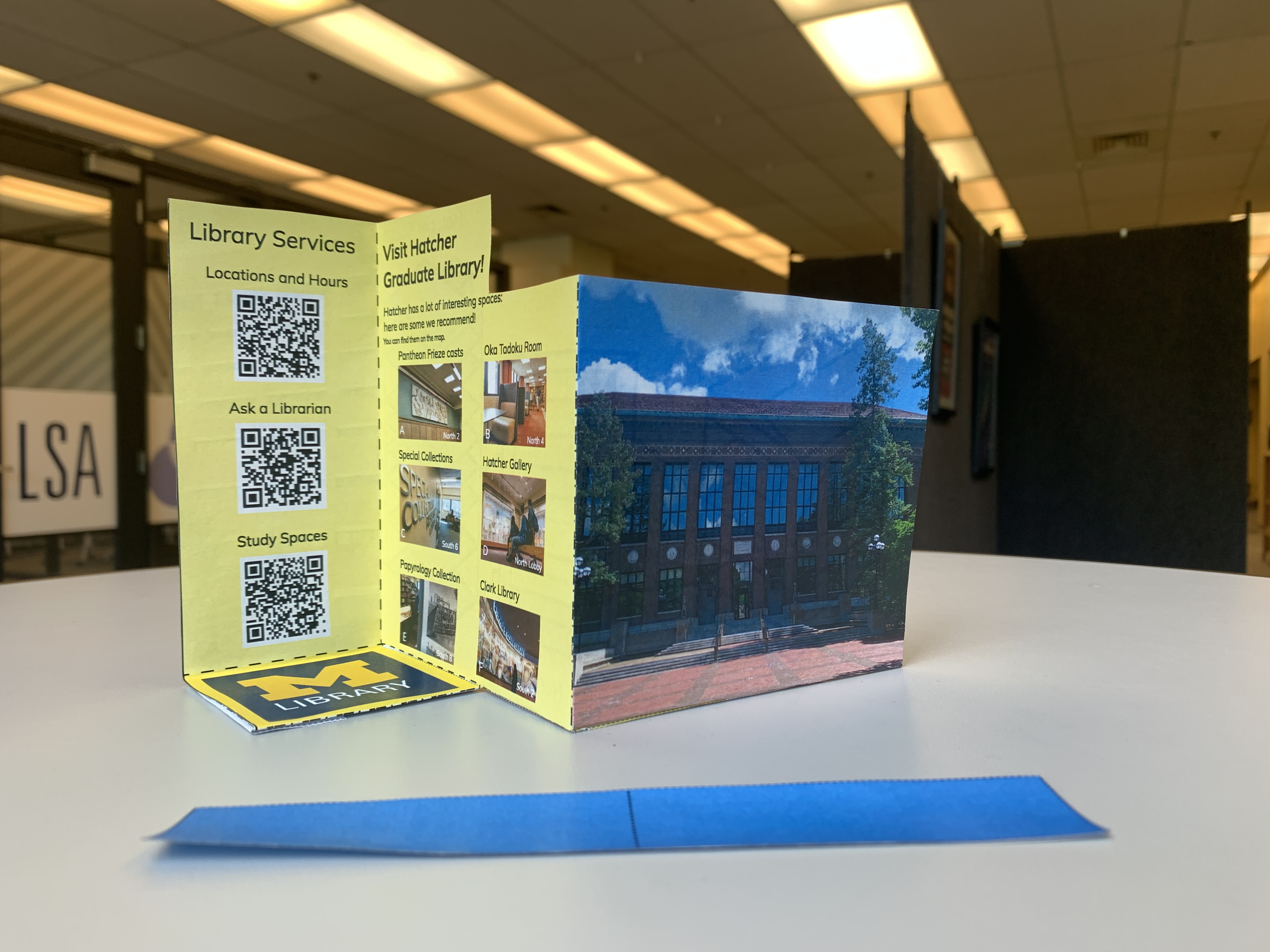 The back side of the pamphlet, with a picture of Hatcher north entrance, some information about the international components of the Library, and some QR codes to useful library services.