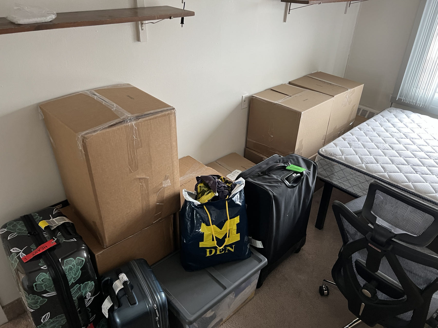 Picture of several cardboard boxes and luggages in the author's new apartment room