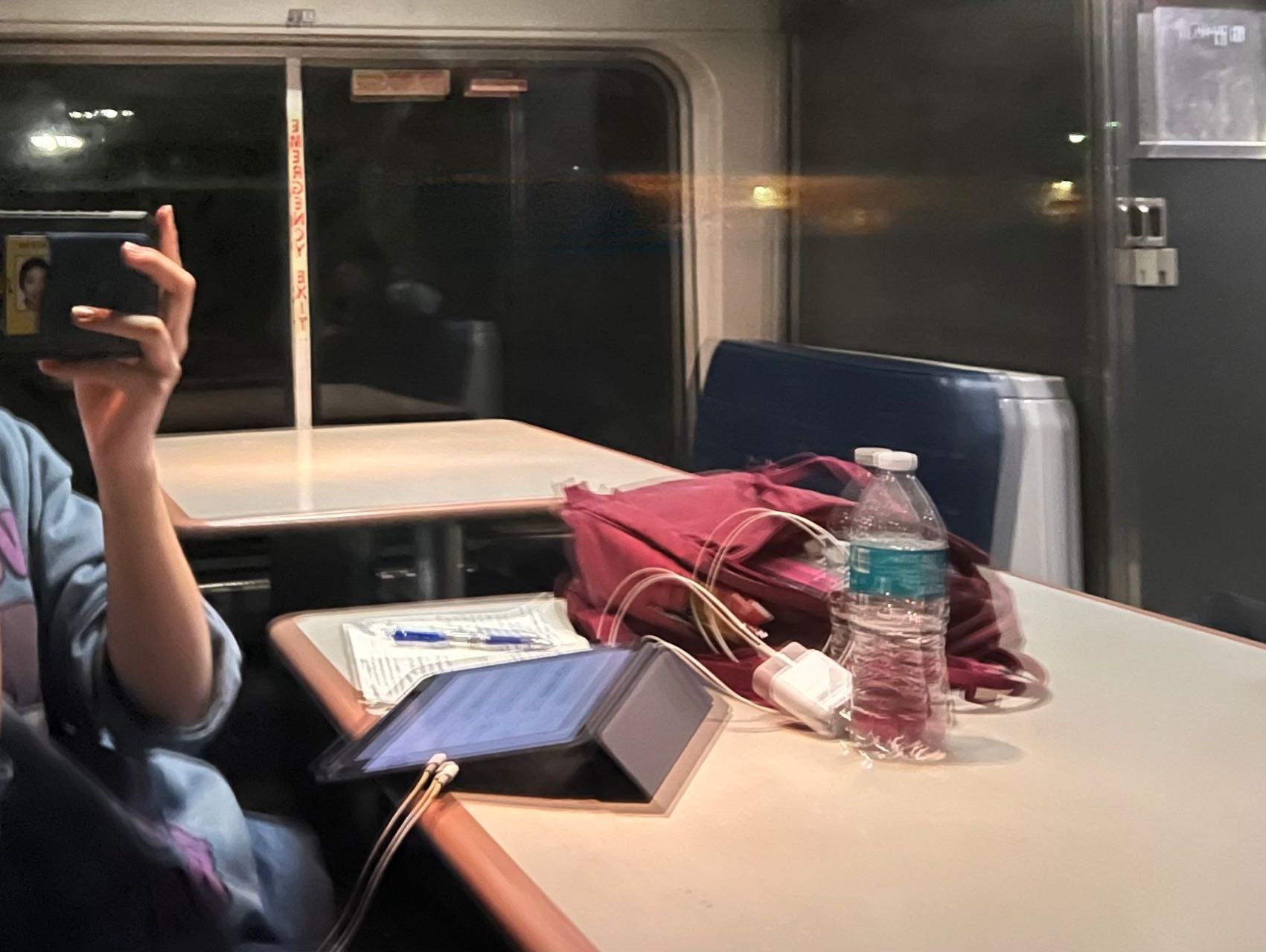 Picture of the author's reflection from a train's window, with iPad open on the desk