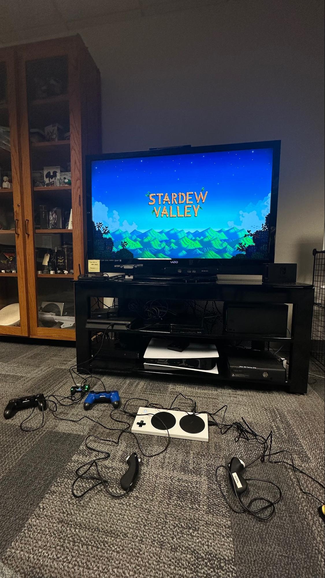An Xbox Adaptive contrller with various controllers attached, and Stardew Velley splash screen on the television
