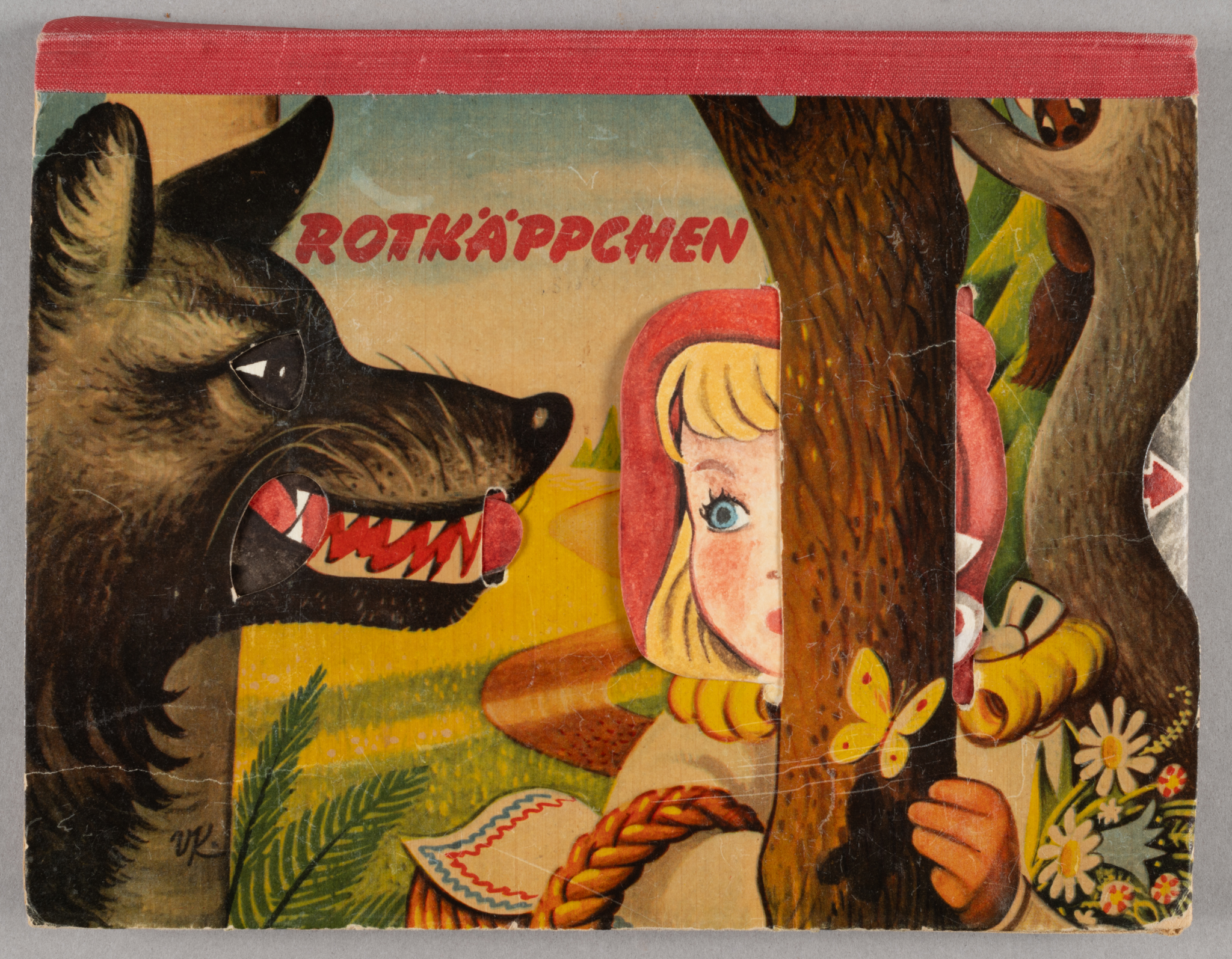 repaired pop up book cover with image of wolf, tree, and girl wearing red hood