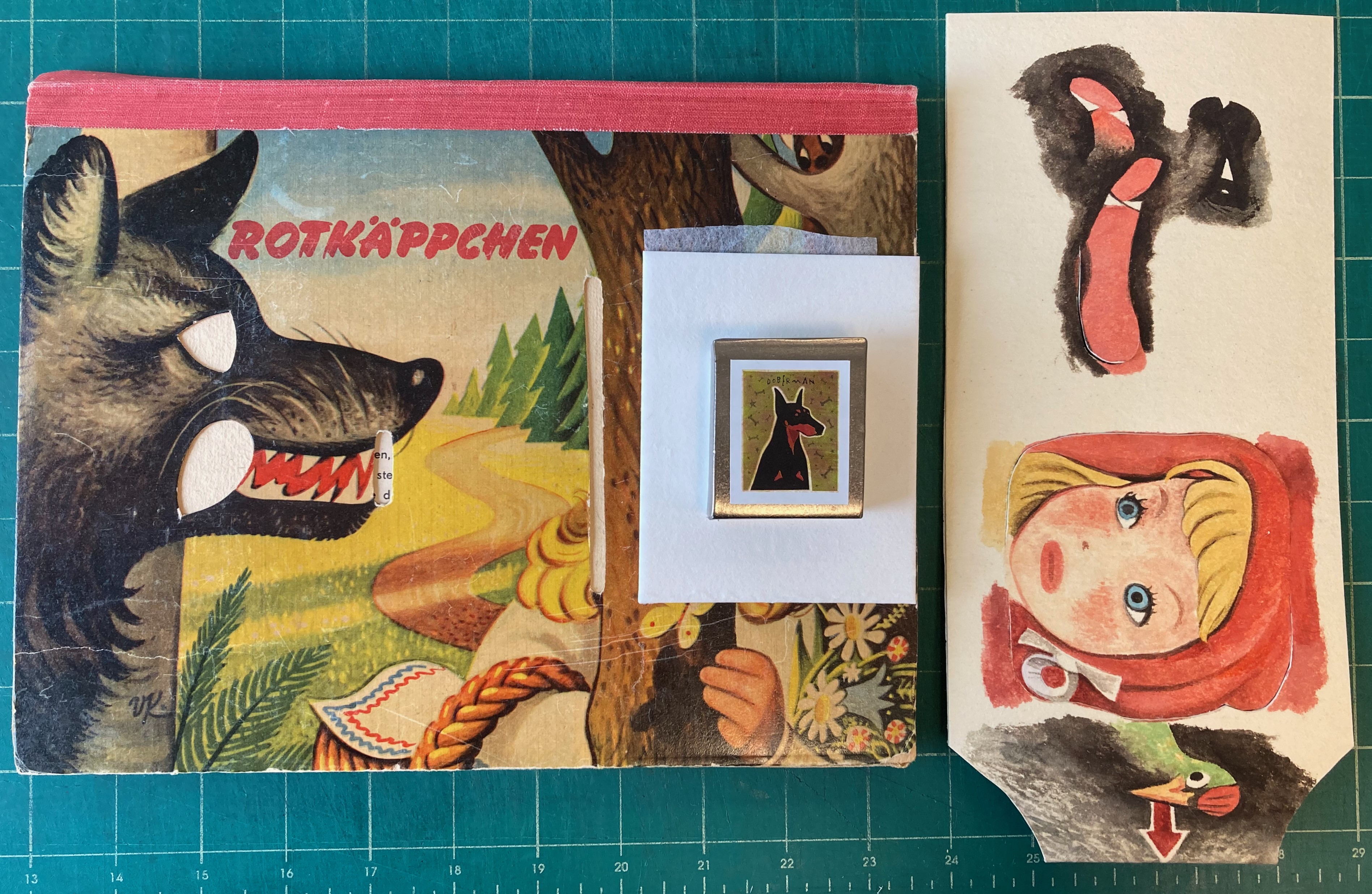 pieces of a pop up book cover with image of wolf, tree, and girl wearing red hood