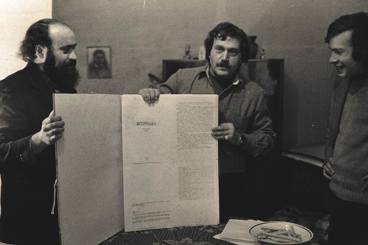 three writers standing holding Ardis printed copy of a text