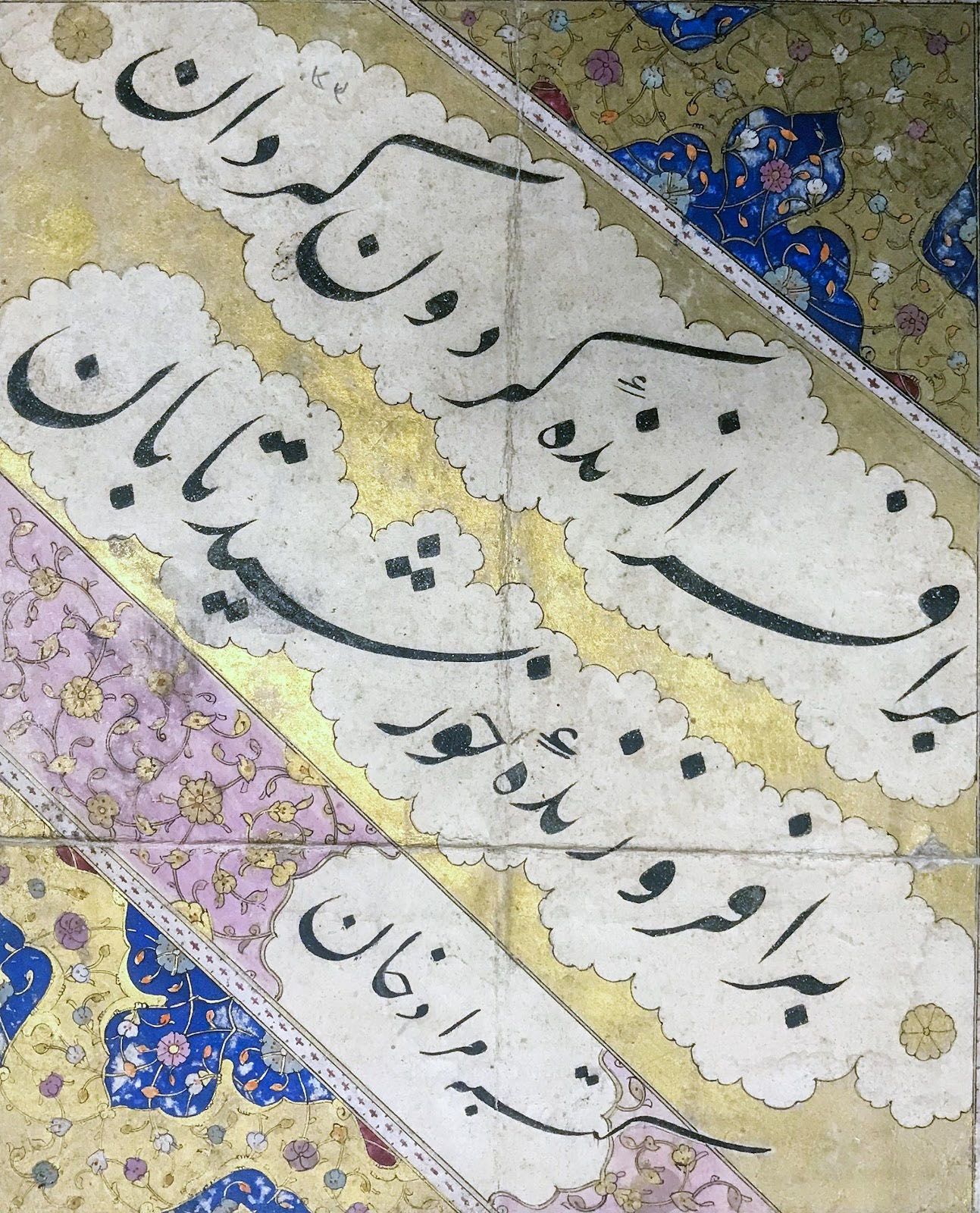 lines of Persian calligraphy in modified Arabic script on the diagonal surrounded by gold and colored painted decorations