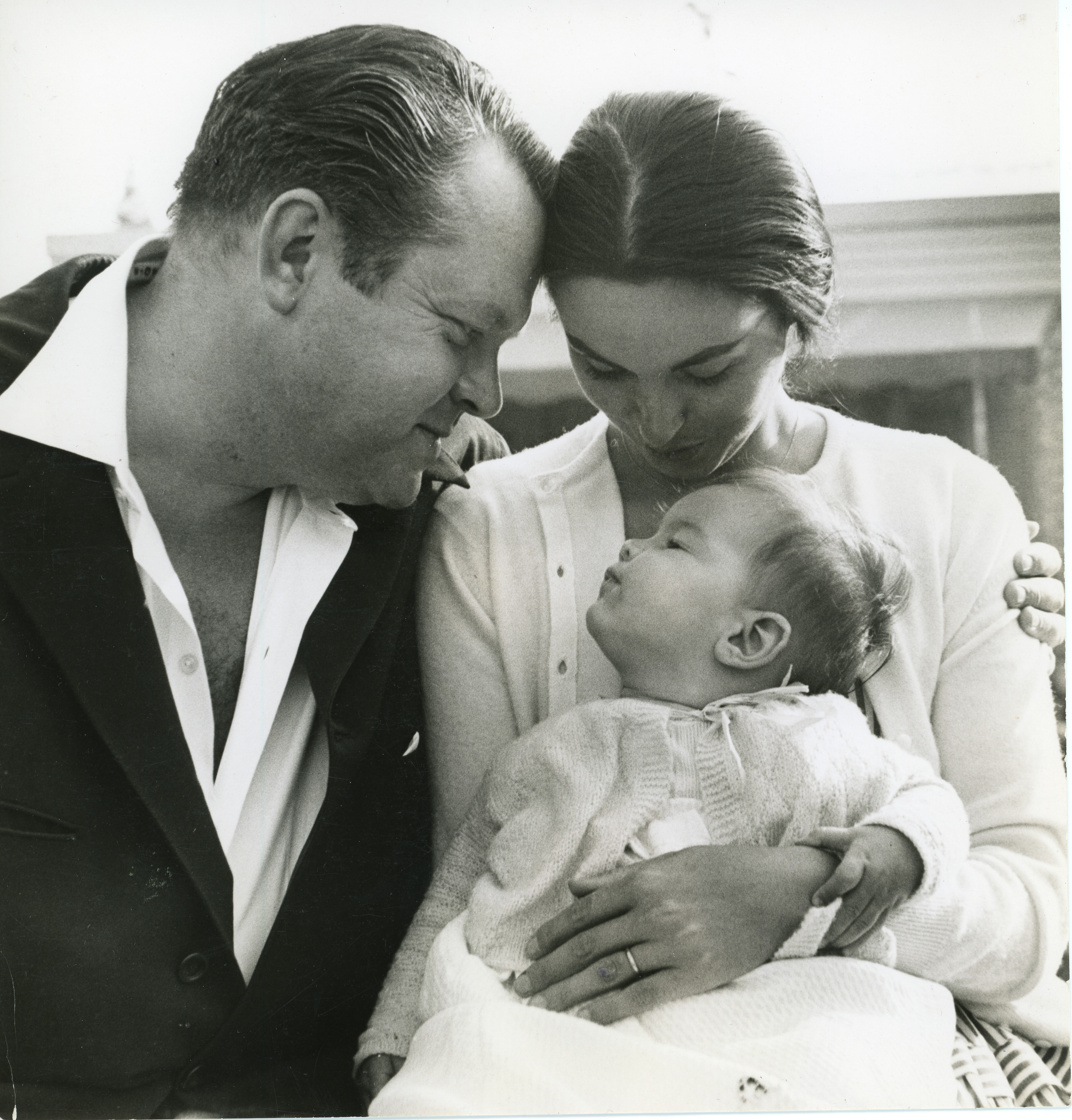 Orson Welles and Paola Mori look adoringly at their infant daughter, Beatrice (c. 1955).