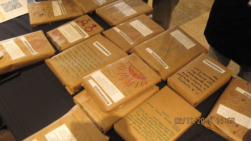 Books, wrapped in brown paper and with description written on them, are set across a table for selection.