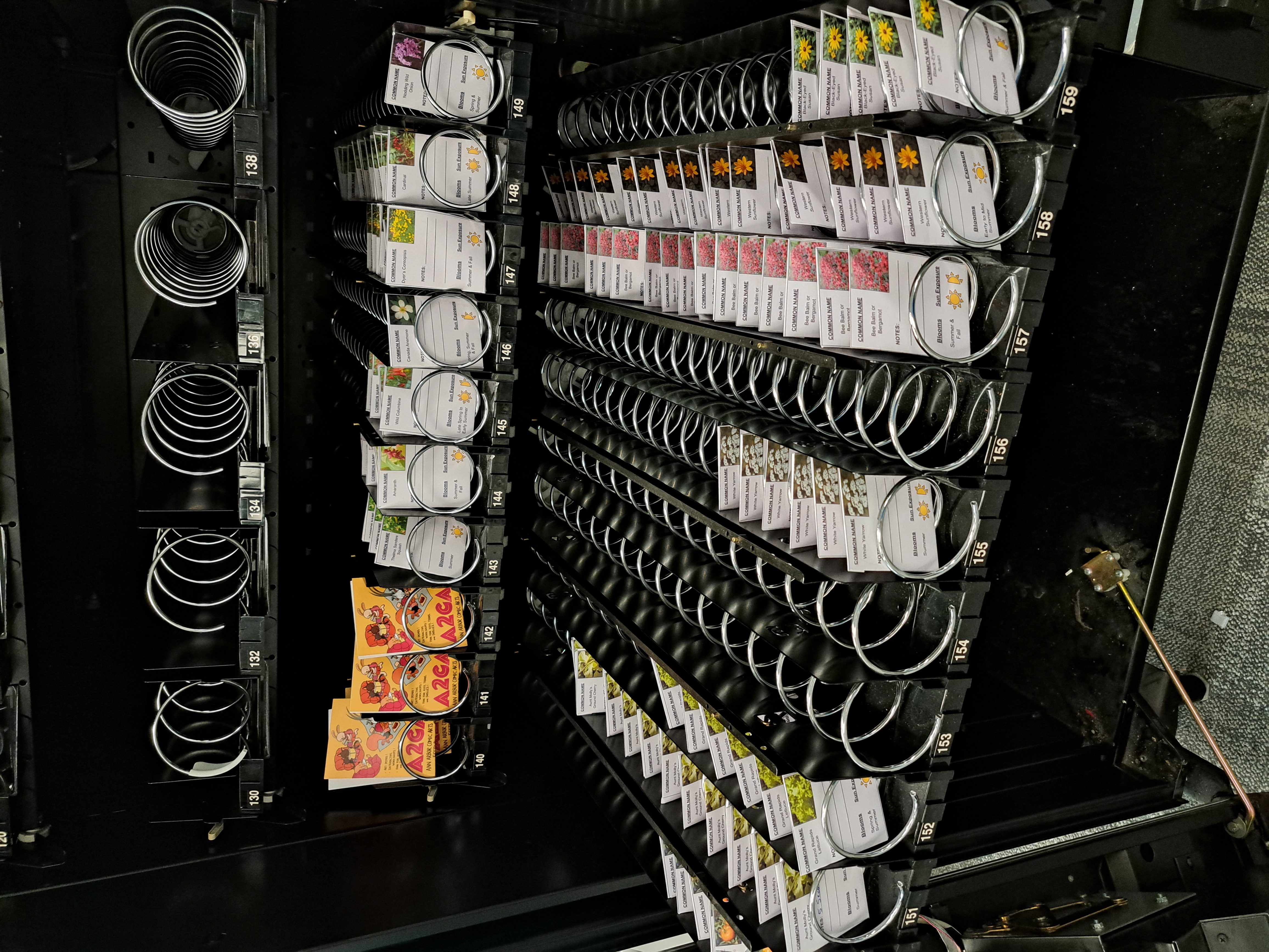 A vending machine is open, showing the rows of different seeds available