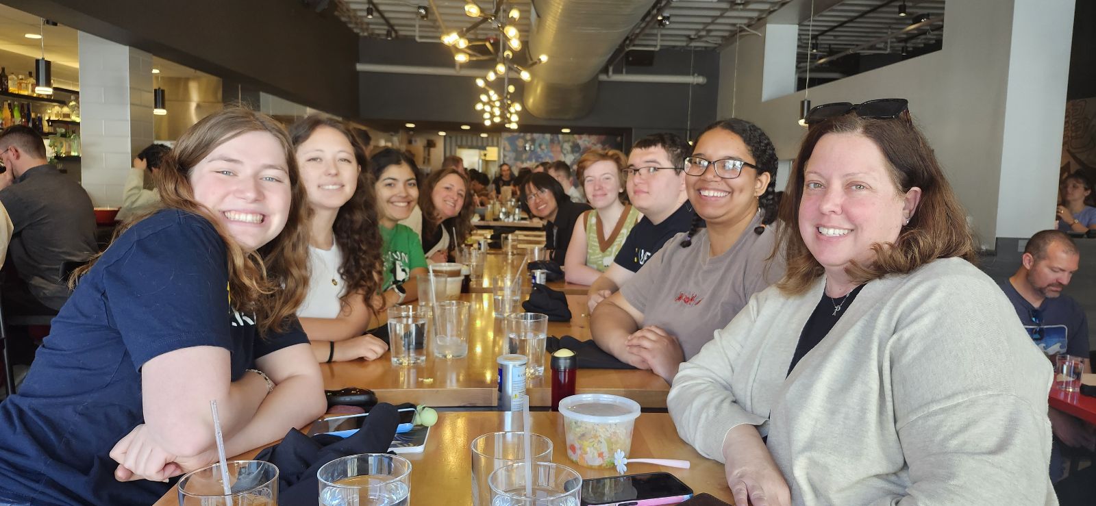 Staff from the University of Michigan Library gather around a table for food