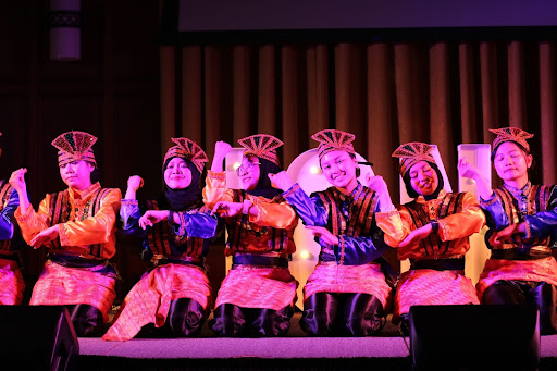 Depicts a photo of dancers performing a traditional Indonesian dance (Ratoe Jaroeh) on a stage.