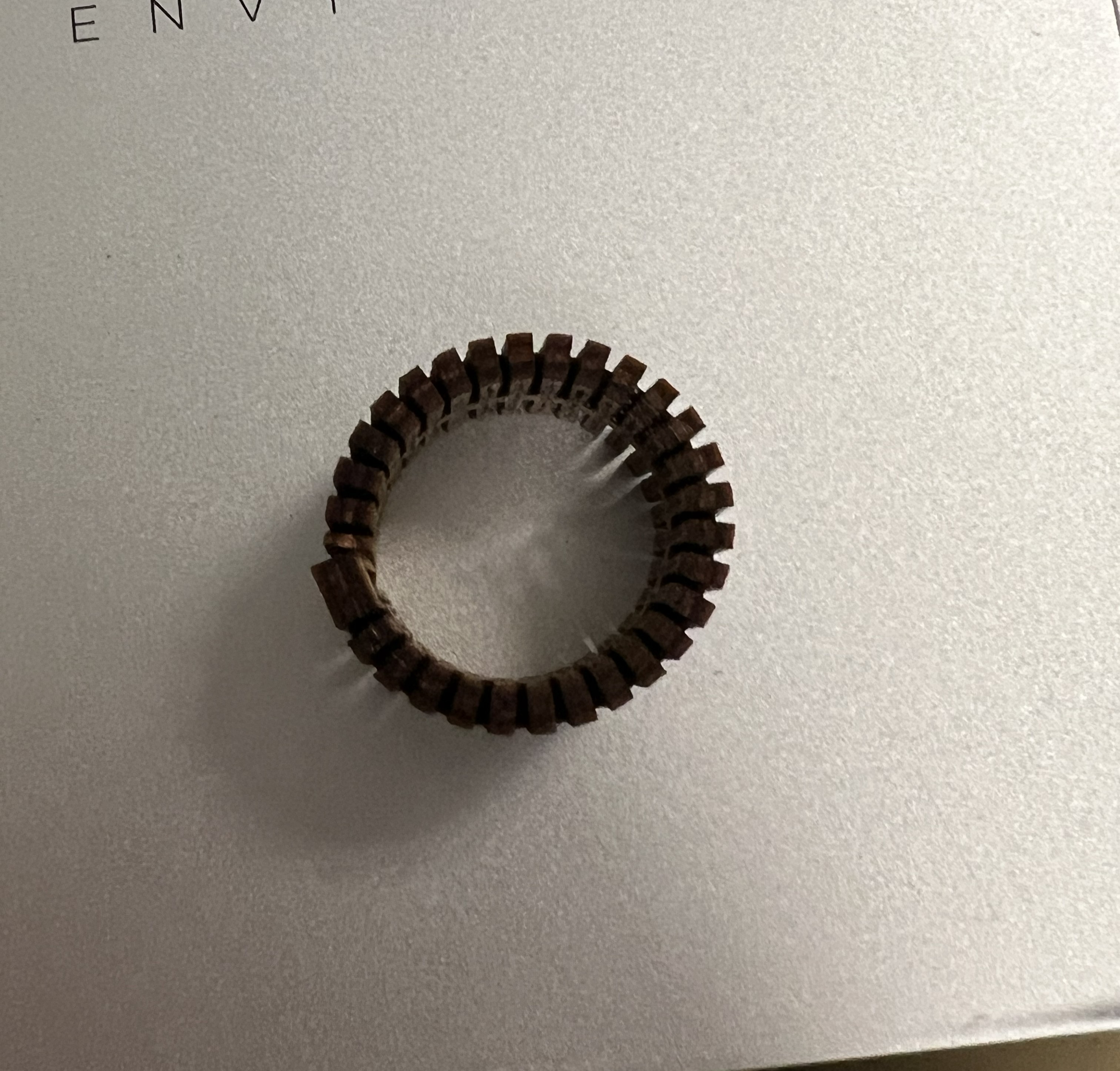 Top-down view of a plywood ring. The ring is latticed, and has an accordion texture shown on the sides.