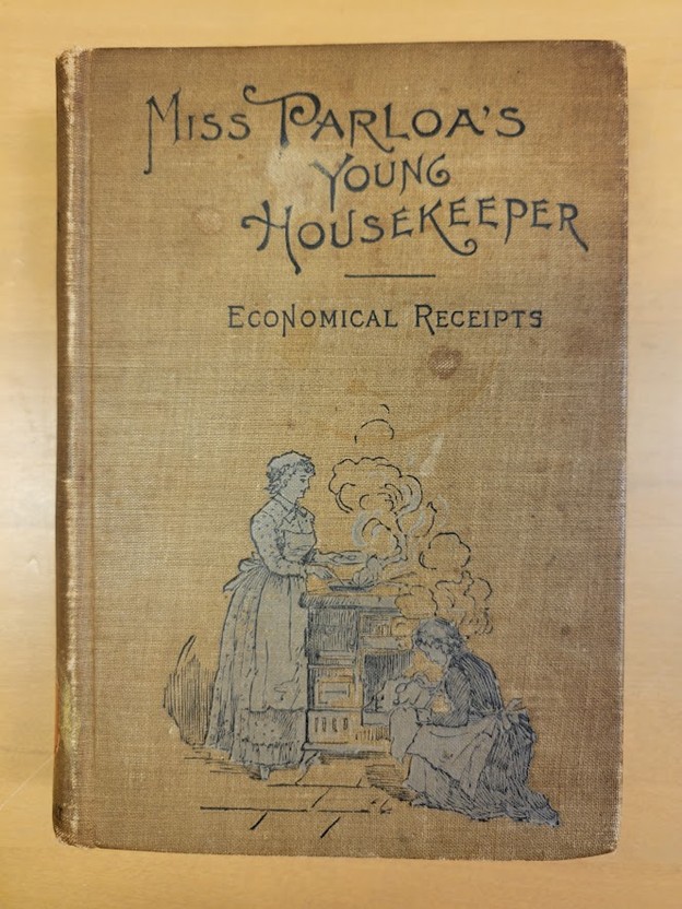 Tan bookcloth cover with the title of the book at the top and a gray and white line illustration of a woman in 19th c. dress at a stove near the bottom