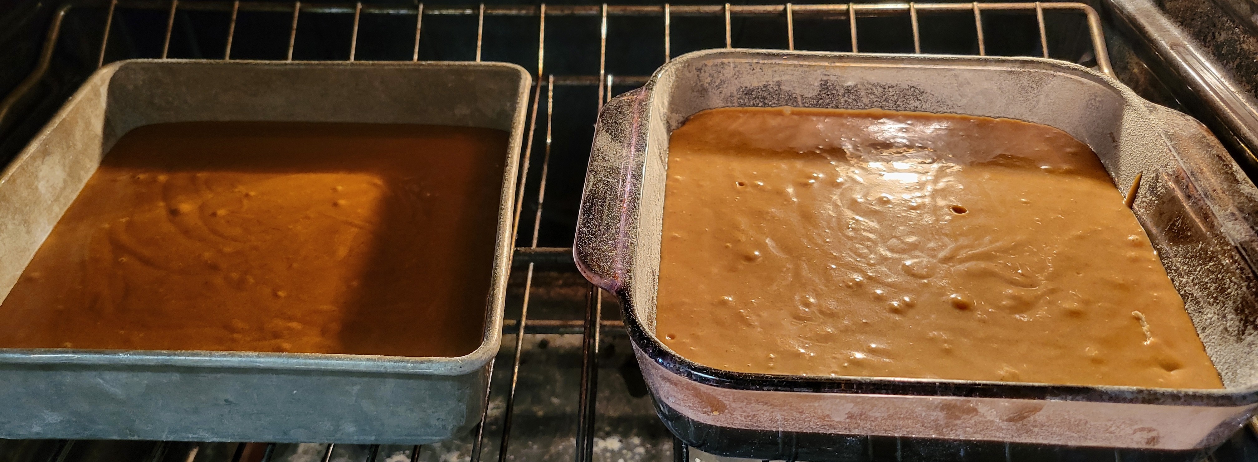 Two pans of gingerbread cake in the oven. The one on the left is darker brown