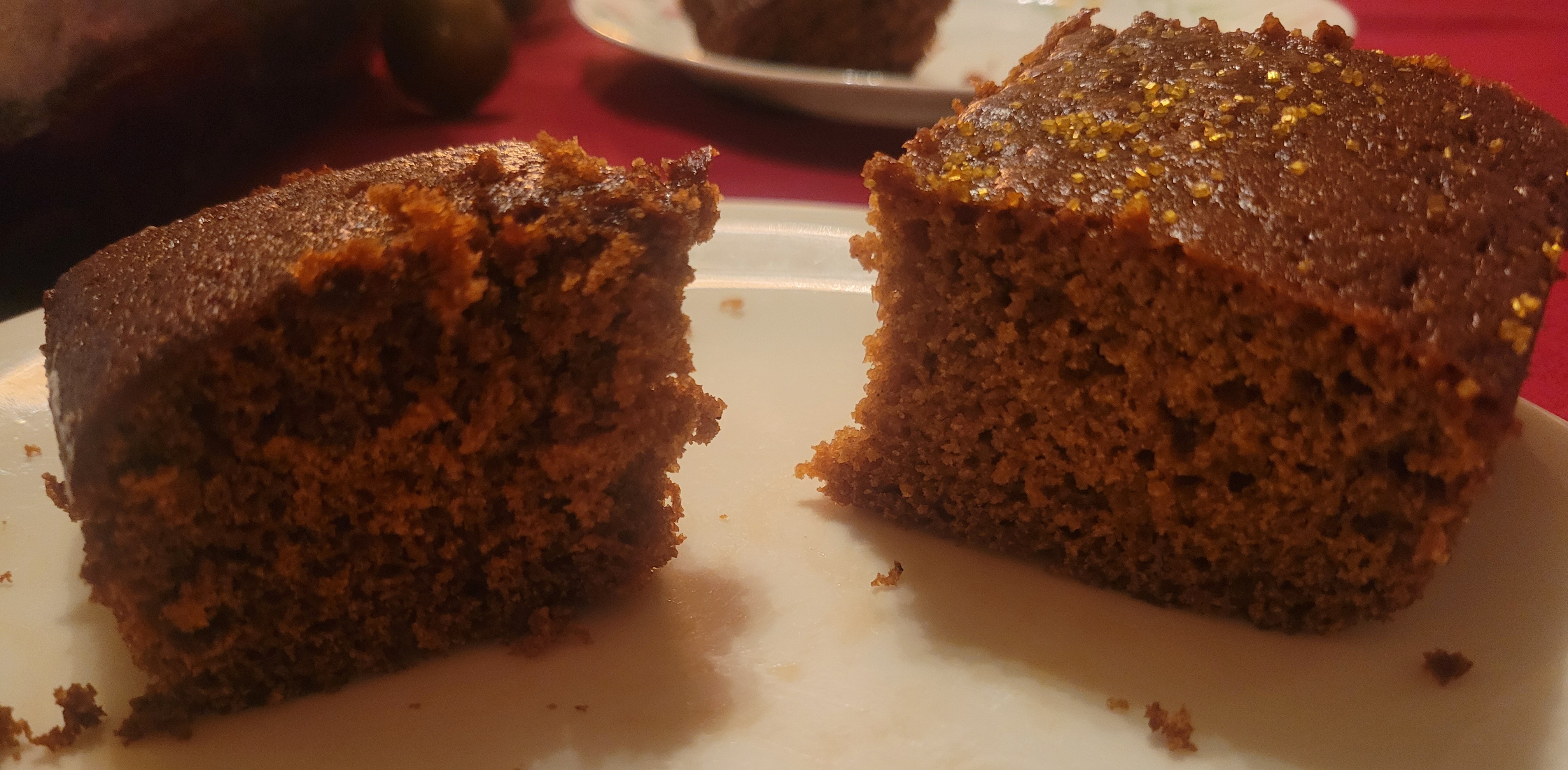 Two slices of gingerbread cake. The one on the left is slightly darker and has a heavier crumb