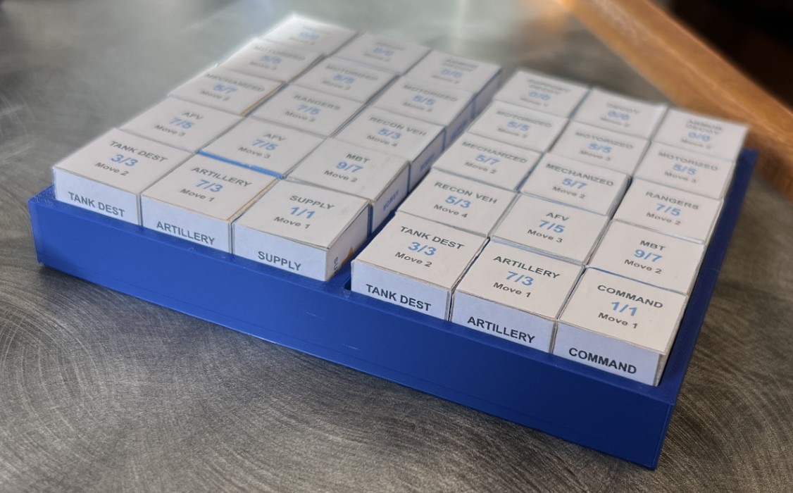 A blue short 3D printed tray completely filled with white cubes. each white cube has writing on each face.