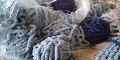 A pile of thick gray and dark blue yarn