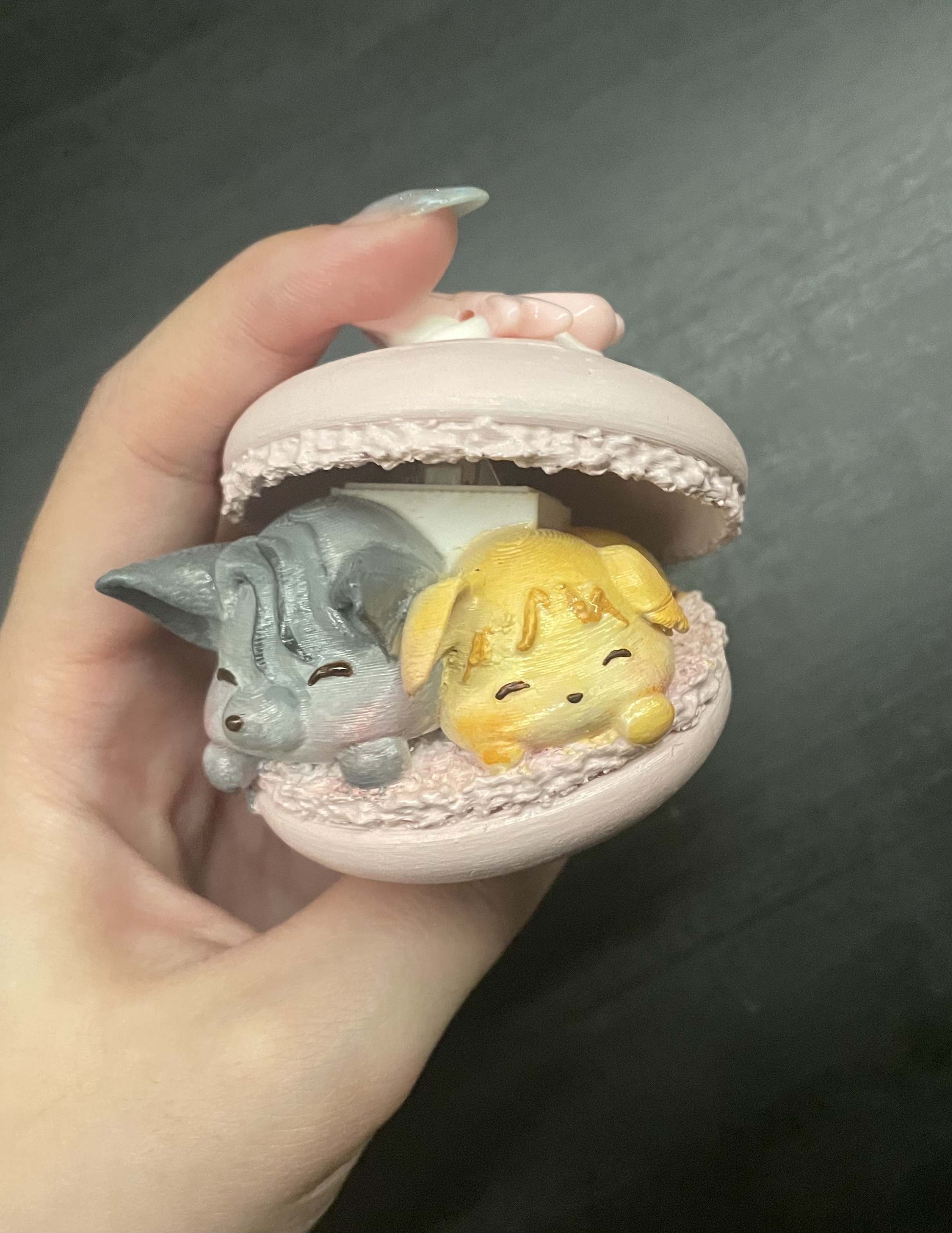grey and yellow kawaii creatures in a pink macaron fidget clicker 