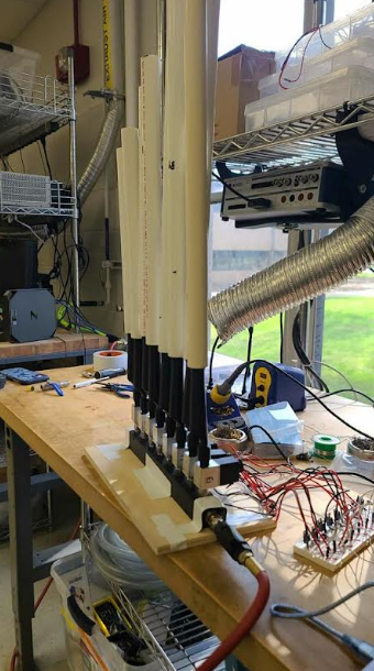 Partially finished pan flute in a crowded laboratory workspace