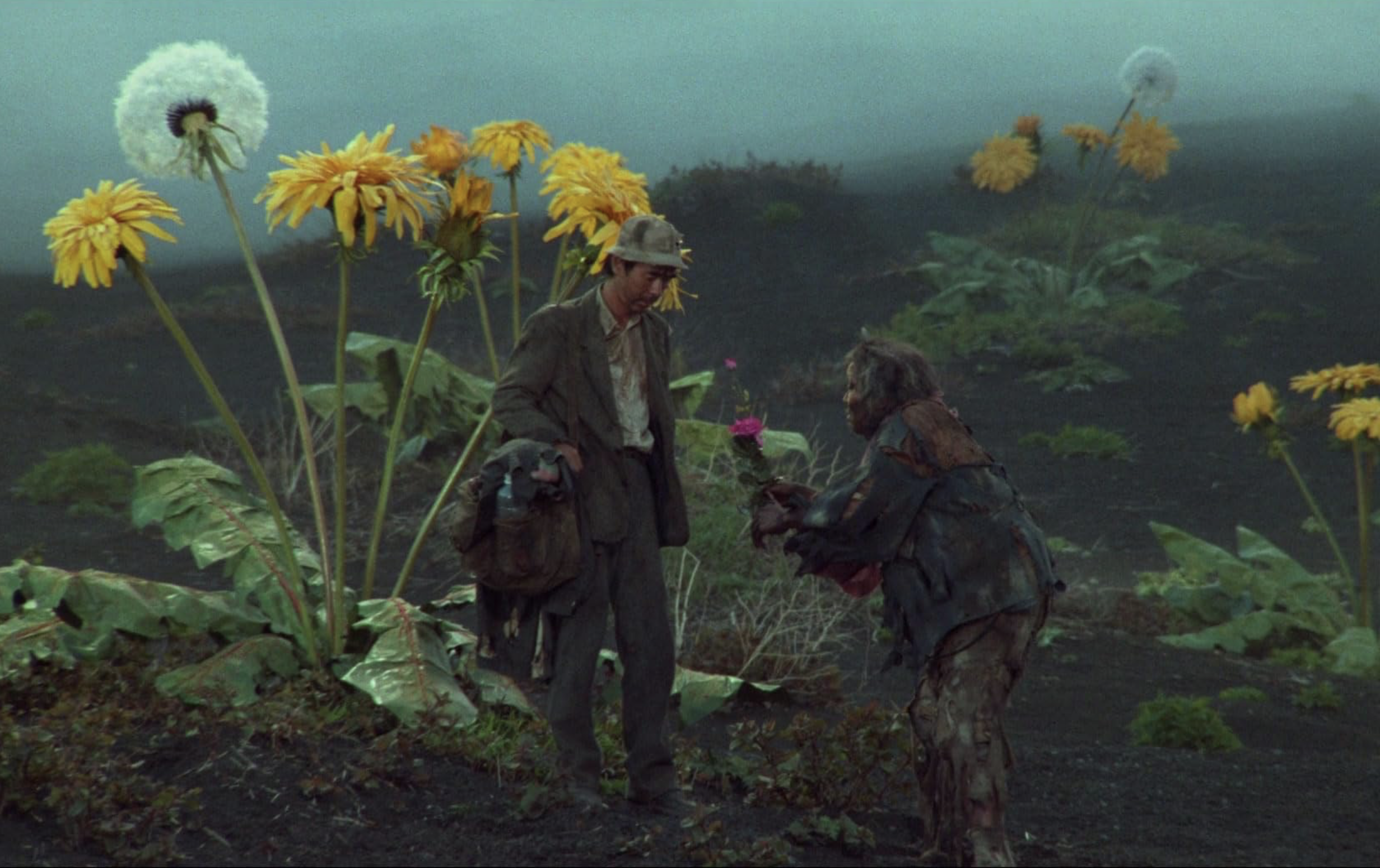 Two people are surrounded by giant dandelions sprouting from the ground.