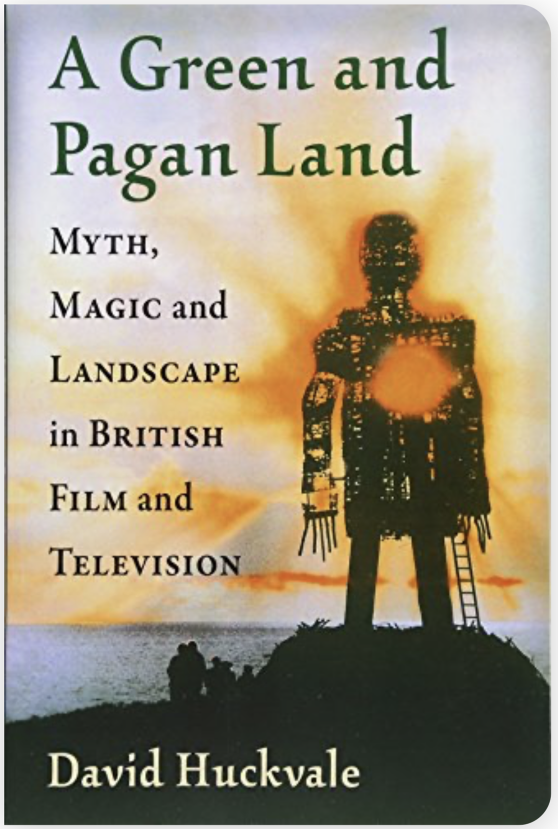 Book cover shows silhouette of rural seaside at dawn or dusk with giant effigy with either a hole in its heart or a burning chest.