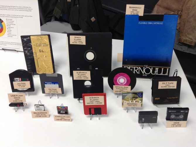 A table display of 15 vintage floppy disks and other forms of digital storage media