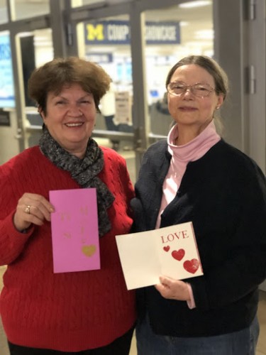Two women holding up letterpressed Valentine's Day cards