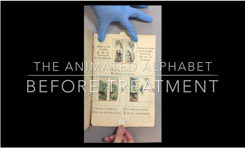 video still with gloved hand and book