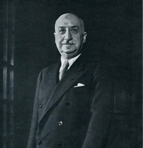 Black and white portrait of De Marinis in double-breasted suit