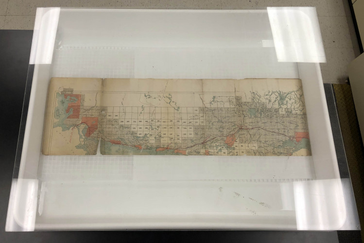 Photograph shows the humidification chamber used to relax and flatten the map. The map had split in half along the centerfold prior to conservation treatment. This made humidifying the map relatively easy because it could be done in small sections.