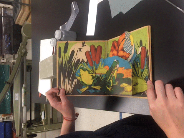 hands opening the pages of a pop up book 