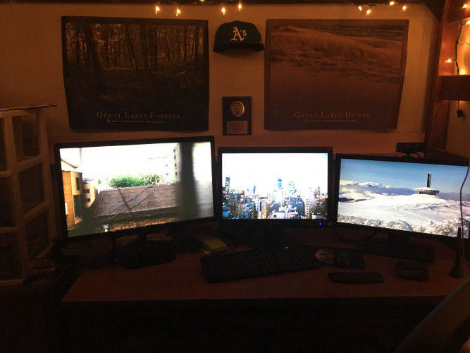 Desk with 3 monitors and wall displaying baseball cap on 3D printed mount