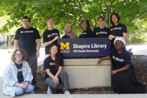 The Library Student Ambassador team for the 2025-2026 academic year standing in front of the Shapiro Library sign.