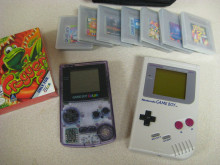 A Game Boy Color and original Game Boy dominated the center of the photo, with a box for Frogger for Game Boy Color on the left and an array of Game Boy cartridges in cases across the top.