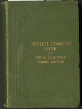 Green cloth-bound book with blind stamped (no color added) border of vines. Title in gold type: Jewish Cookery Book by Mrs. J. Atrutel Second Edition
