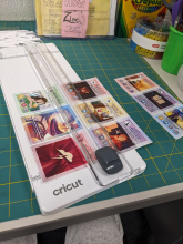 Cutting mat with laminated sheet of cards on it being cut apart