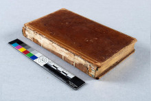 view of a closed book with damage to spine visible