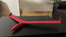 A red, 3D printed glider that consists of wings and a central body.