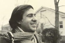 headshot of victor perera smiling in front of a house with bare trees and bushes