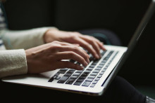 Stock image of hands typing on a laptop, for decorative purposes.