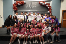 Members of various Greek Life organizations, who are wearing their merchandise (e.g. Lambda Theta Alpha Latin Sorority sisters are wearing white and red), gather together for a group photo at the 19th Annual Multicultural Greek Exhibition (MGX) 2025 