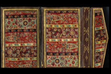 Rectangular covers and pentagonal flap with bands of colorful floral vegetal designs surrounded by brown leather frame boarders