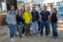 Picture of ten researchers in front of a gas flare