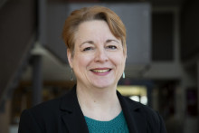 Picture of Dr. Kathy Klinich, a middle aged white woman wearing a green shirt and black blazer smiling at the camera