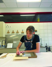 student using tool to repair paper sheet music