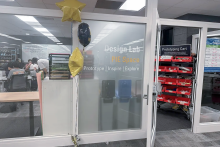 Balloons in front of a glass wall and open door to the entrance of the Shapiro Design Lab PIE Space