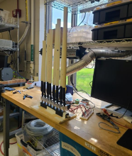 A pan flute prototype on a crowded laboratory work bench