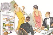 A woman in a sleeveless gown serves drinks and snacks from a fridge to three guests in evening wear (men in suits; another woman in a sleeveless gown)