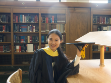 Muyu Lin wearing graduation gown and holding the graduation cap