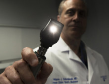 Doctor shining a light into the camera 