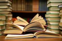 Image of books stacked and lying open.