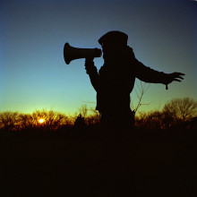 Silhouette of a woman with a megaphone.
